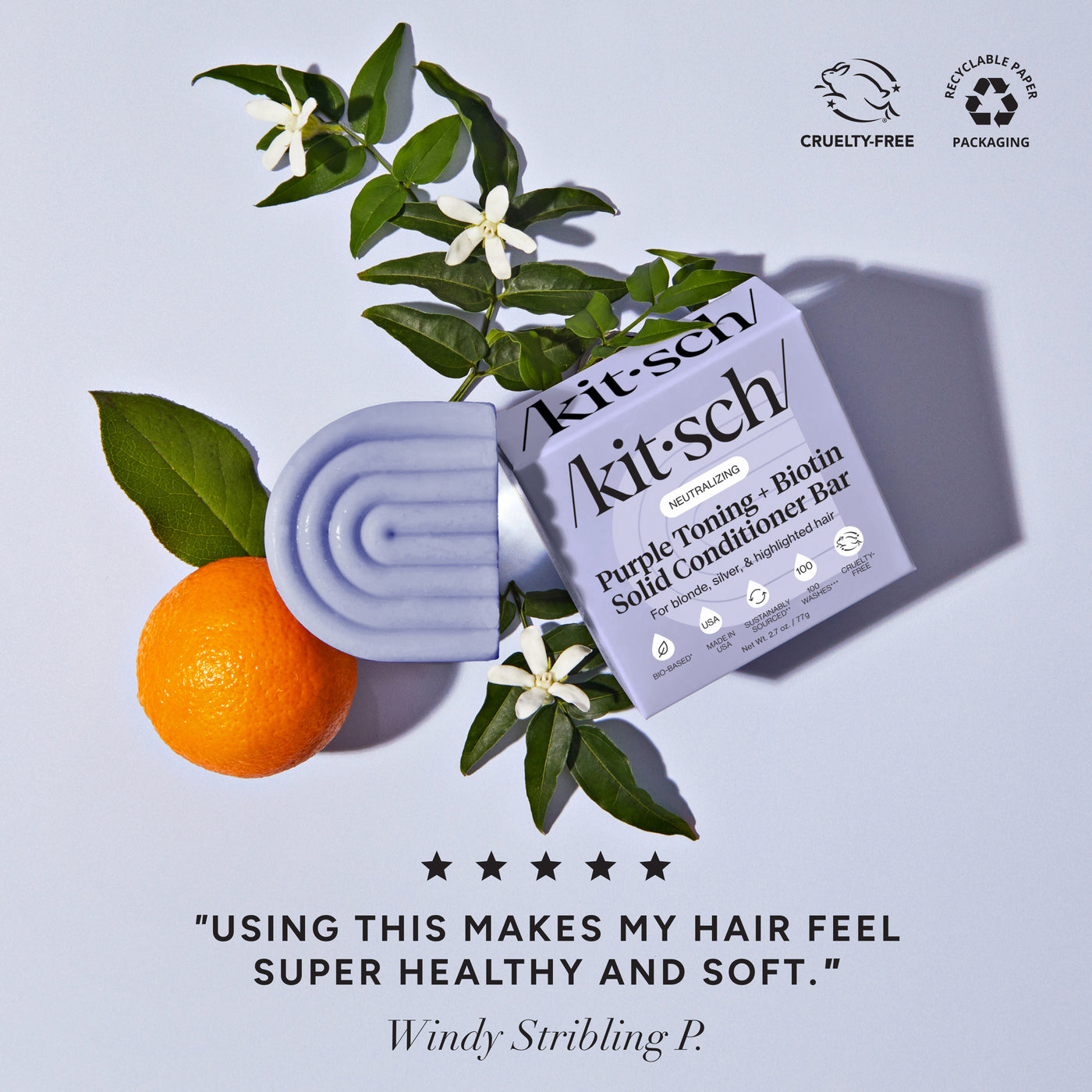 Lifestyle flat-lay of Kitsch Purple Toning Conditioner Bar styled with orange blossoms on a soft background